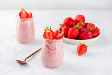 Mousse dessert of tofu and strawberries in glass cups on a white table. Lactose and sugar free.
