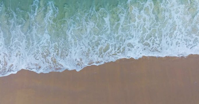 Beautiful sea summer landscape, Waves sea water surface High quality video Bird's eye view, Drone top view waves crashing on sand beach,Nature ocean sea beach background