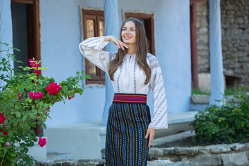 Naklejka premium Beautiful traditional costume from Republic of Moldova. Young girl wearing Romanian traditional blouse.