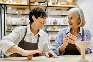 A lesbian couple crafts pottery together in a cozy studio.