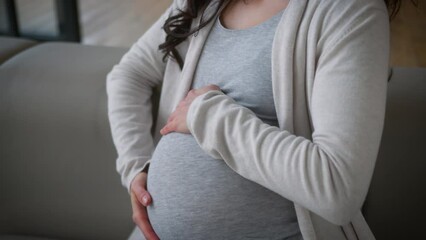 Dreaming inspired happy smiling alone single future mother pregnant woman relaxing at home couch sofa enjoying pregnancy girl female stroking touch big belly anticipation childbirth health medicine