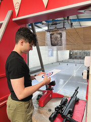 Young man examining a target at a shooting range