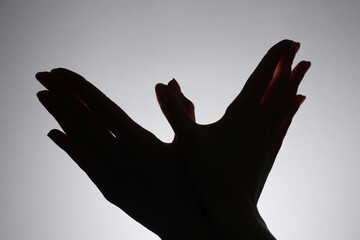 Shadow puppet. Woman making hand gesture like bird on grey background, closeup