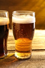 Glasses with different types of beer on wooden table, closeup