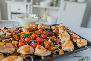 Chicken skewers with roasted mediterranean vegetables on a platter