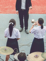 Group of Asian students in uniform perform a orchestra band in festival performance at stadium....