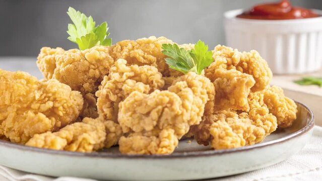 Breaded chicken strips in slow motion. Chicken fingers.