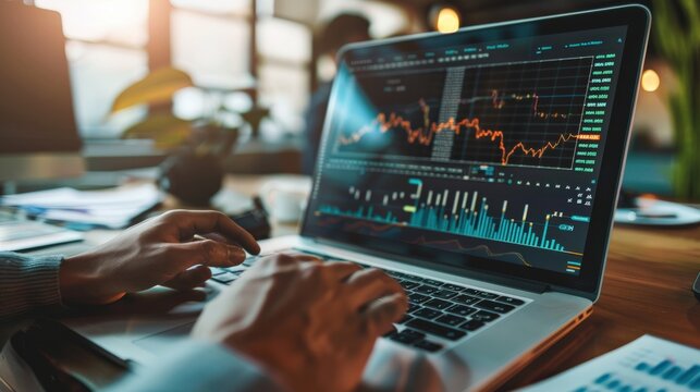 A laptop with a green plant on the desk and a bottle of water next to it. The laptop screen shows a graph with multiple lines and numbers