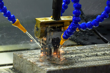 The graphite electrode working on EDM machine with liquid coolant method.