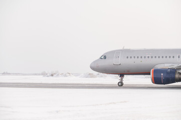 Fototapeta premium Parked airplane at the airport in winter. 