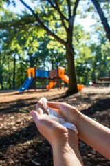 Hands Gently Cleaned with Eco-Friendly Wipe in Park Playground Setting for Sustainable Living