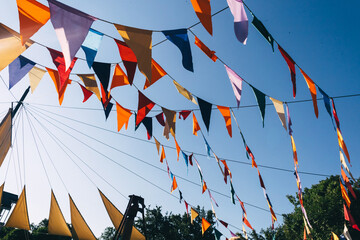 A garland of flags hung in the park at the carnival. Multicolored decoration for the holiday and...