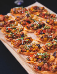 Beautifully decorated banquet catering table, with variety of with different food snacks appetizers on corporate birthday party event or wedding celebration, canape, salad, delicatessen setting