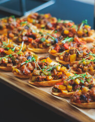 Beautifully decorated banquet catering table, with variety of with different food snacks appetizers on corporate birthday party event or wedding celebration, canape, salad, delicatessen setting