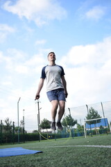 A young man in sportswear engages in a workout, using a sport tool for physical exercises on a...
