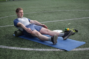 A young man in sportswear engages in a workout, using a sport tool for physical exercises on a...