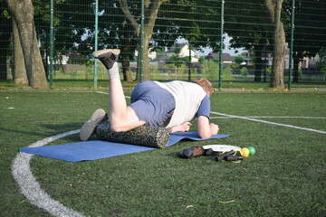 A young man in sportswear engages in a workout, using a sport tool for physical exercises on a...