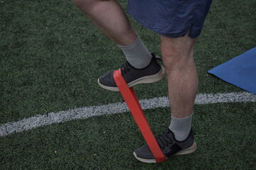 A young man in sportswear engages in a workout, using a sport tool for physical exercises on a...