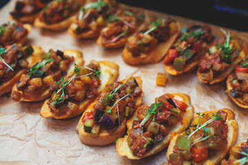 Beautifully decorated banquet catering table, with variety of with different food snacks appetizers on corporate birthday party event or wedding celebration, canape, salad, delicatessen setting