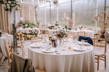 Valmiera, Latvia - September 9, 2023 - Elegant wedding reception setup with round tables, floral...