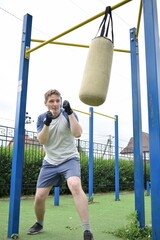 Obraz premium A dedicated young athlete boxing, puts in the hard work, training on gym equipment outdoors to prepare his body. He builds strength and endurance before hitting the field or court for competition