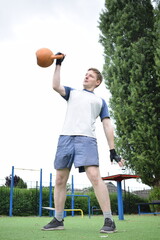 A young man in sportswear engages in a workout, using a sport tool for physical exercises on a...