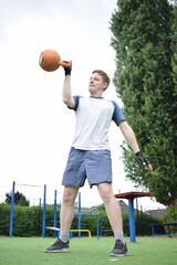 A young man in sportswear engages in a workout, using a sport tool for physical exercises on a...