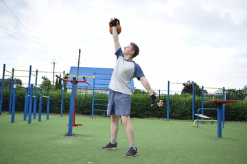 A young man in sportswear engages in a workout, using a sport tool for physical exercises on a...