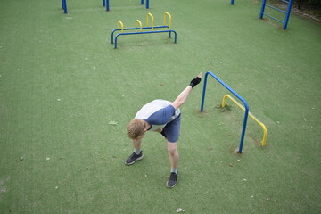 A young man in sportswear engages in a workout, using a sport tool for physical exercises on a...