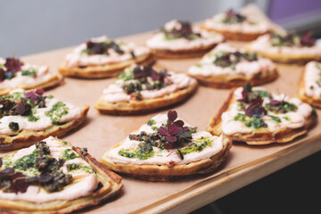 Beautifully decorated banquet catering table, with variety of with different food snacks appetizers on corporate birthday party event or wedding celebration, canape, salad, delicatessen setting