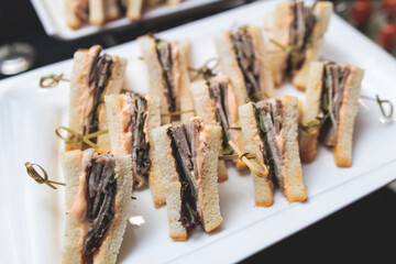 Beautifully decorated banquet catering table, with variety of with different food snacks appetizers...