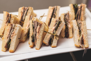 Beautifully decorated banquet catering table, with variety of with different food snacks appetizers on corporate birthday party event or wedding celebration, canape, salad, delicatessen setting