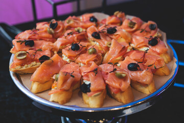 Beautifully decorated banquet catering table, with variety of with different food snacks appetizers on corporate birthday party event or wedding celebration, canape, salad, delicatessen setting