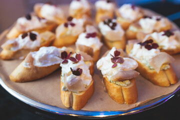 Beautifully decorated banquet catering table, with variety of with different food snacks appetizers on corporate birthday party event or wedding celebration, canape, salad, delicatessen setting