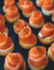 Beautifully decorated banquet catering table, with variety of with different food snacks appetizers on corporate birthday party event or wedding celebration, canape, salad, delicatessen setting