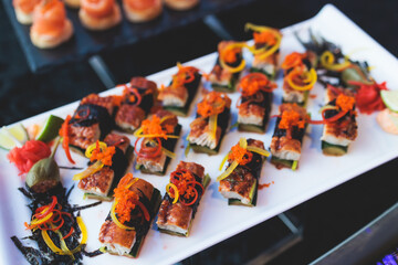 Beautifully decorated banquet catering table, with variety of with different food snacks appetizers on corporate birthday party event or wedding celebration, canape, salad, delicatessen setting