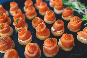 Beautifully decorated banquet catering table, with variety of with different food snacks appetizers on corporate birthday party event or wedding celebration, canape, salad, delicatessen setting