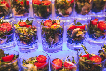 Beautifully decorated banquet catering table, with variety of with different food snacks appetizers on corporate birthday party event or wedding celebration, canape, salad, delicatessen setting