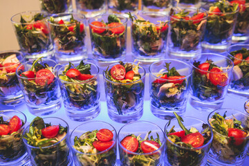 Beautifully decorated banquet catering table, with variety of with different food snacks appetizers on corporate birthday party event or wedding celebration, canape, salad, delicatessen setting