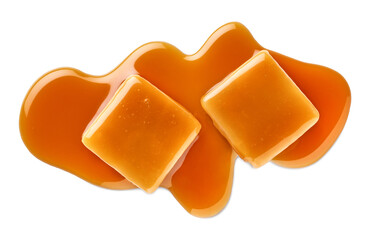 Two sweet caramel candy cubes topped with caramel sauce on white background