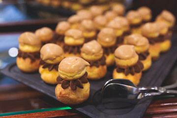 Beautiful multicolored decorated baked sweet tasty candy bar dessert selection with cake, pie and pastries selection, catering banquet table on kids children party, coffee break buffet at a conference