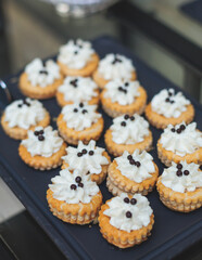 Beautiful multicolored decorated baked sweet tasty candy bar dessert selection with cake, pie and pastries selection, catering banquet table on kids children party, coffee break buffet at a conference