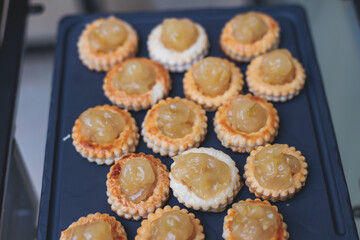 Beautiful multicolored decorated baked sweet tasty candy bar dessert selection with cake, pie and pastries selection, catering banquet table on kids children party, coffee break buffet at a conference