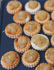 Beautiful multicolored decorated baked sweet tasty candy bar dessert selection with cake, pie and pastries selection, catering banquet table on kids children party, coffee break buffet at a conference