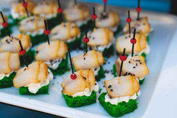 Beautifully decorated luxury banquet catering table, with variety of with different food snacks appetizers on corporate birthday party event wedding celebration, canape, salad, delicatessen variety