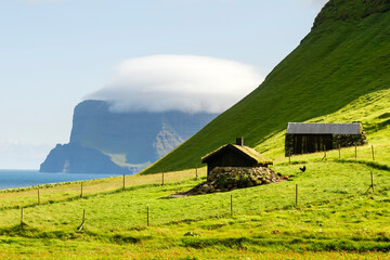 Green hills and grass roof house on summer island Kalsoy in Atlantic ocean, Faroe Islands, Denmark. Landscape photography