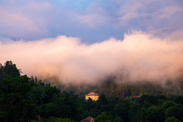 Landscape with a cloud of fog rising in the countryside after rain in the evening