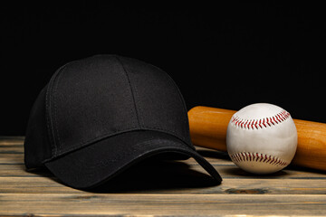 Baseball cap, ball and bat on wooden background