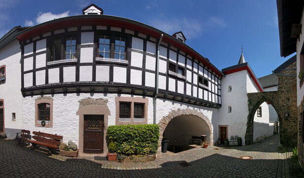 A half-timbered residential house and a city gate in the old town of Kronenburg, Eifel region in Germany