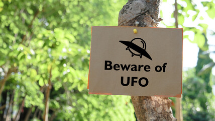 Illustrated with a black UFO space ship the paper sign prominently displays the words Beware of UFO.